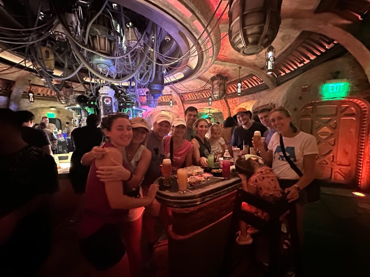 Inside Oga's Cantina at Disney World Resort. Large family with drinks around a table inside the cantina.