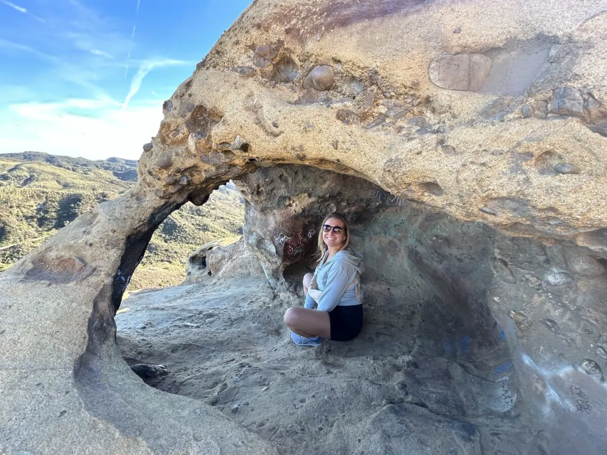 Youngg woman sitting in an open  Cave at Topanga Park near Eagle Rock