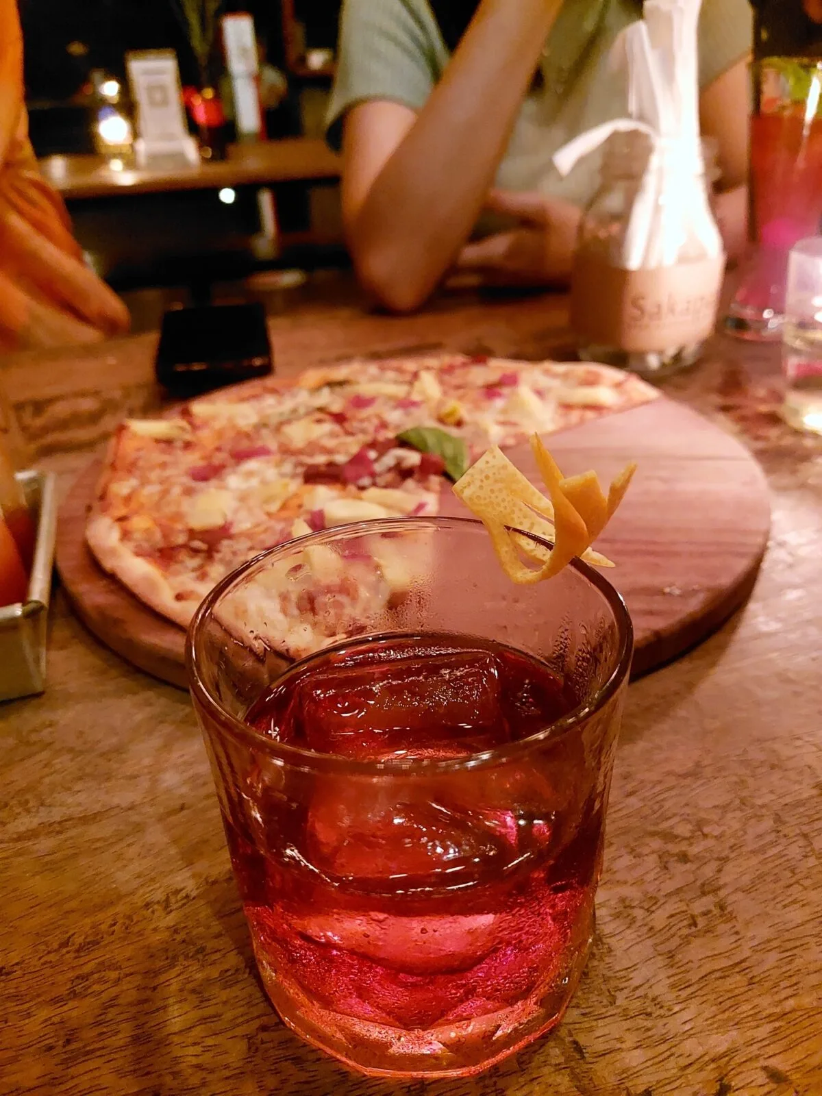  A glass of Negroni and half eaten pizza