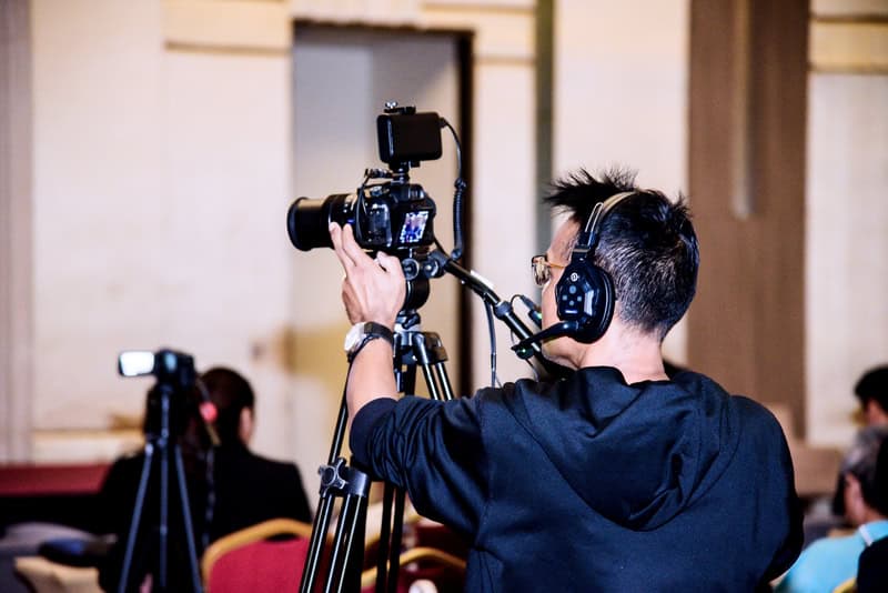 man using a camera and tripod