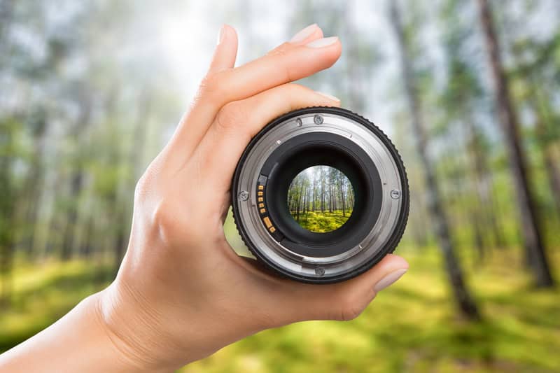 woman's hand holding camera lens