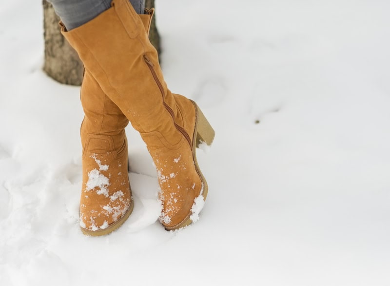 women's yellow winter boots on snow