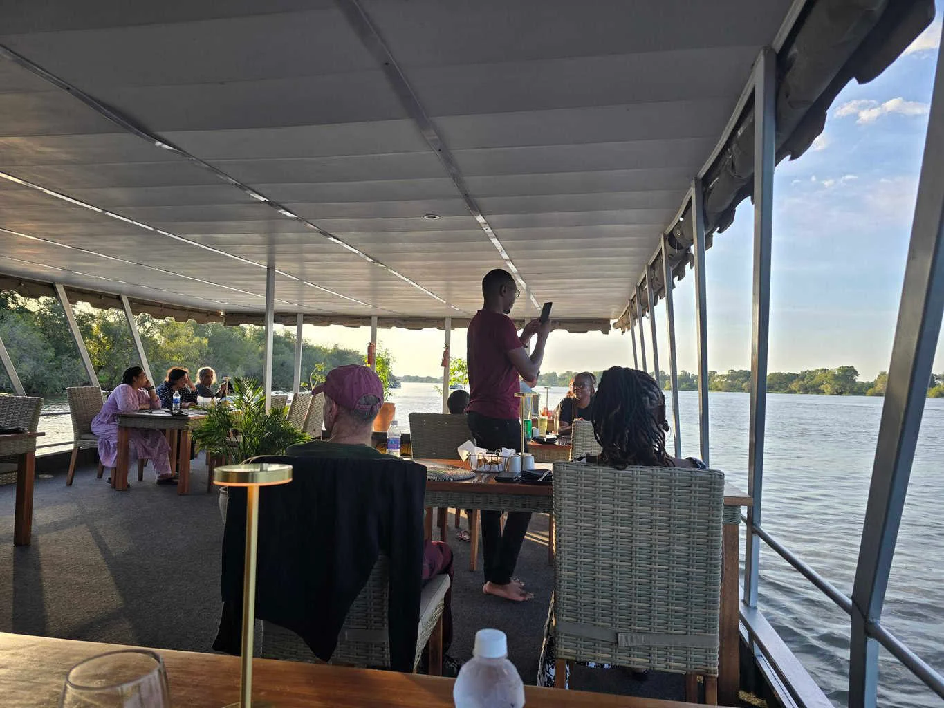 Couple dining al fresco on a boat on the Zambezi when visiting Victoria Falls