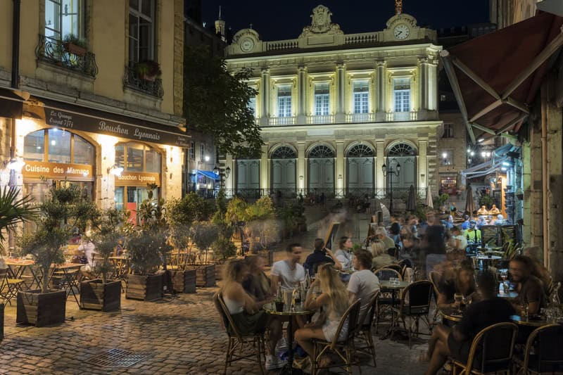 people eating at an outdoor restaurant at night in Lyon, France