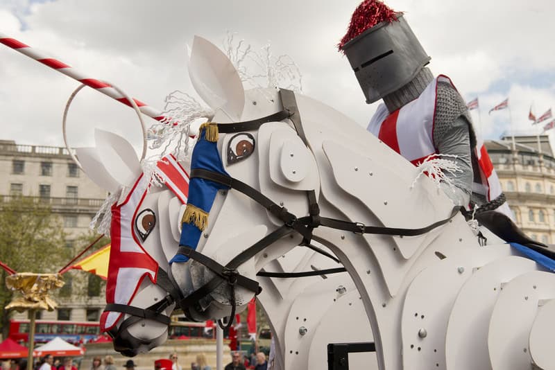 a knight in armor riding a mock horse celebrating St. George's Day in London, England 