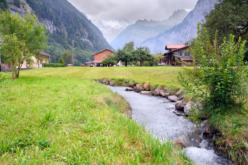 a river and cottages in the Swiss Alps in Spring