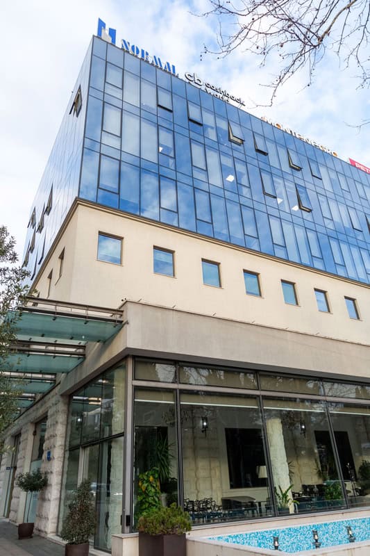 glass building with cloudy sky at Hilton Podgorica Crna Gora in Montegrao