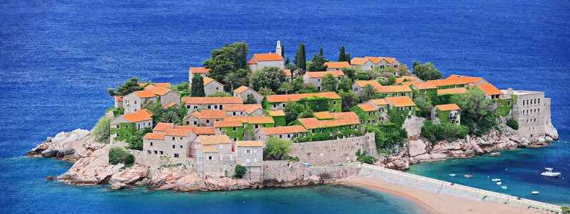 orange roofed buildings on the ocean in Montenegro