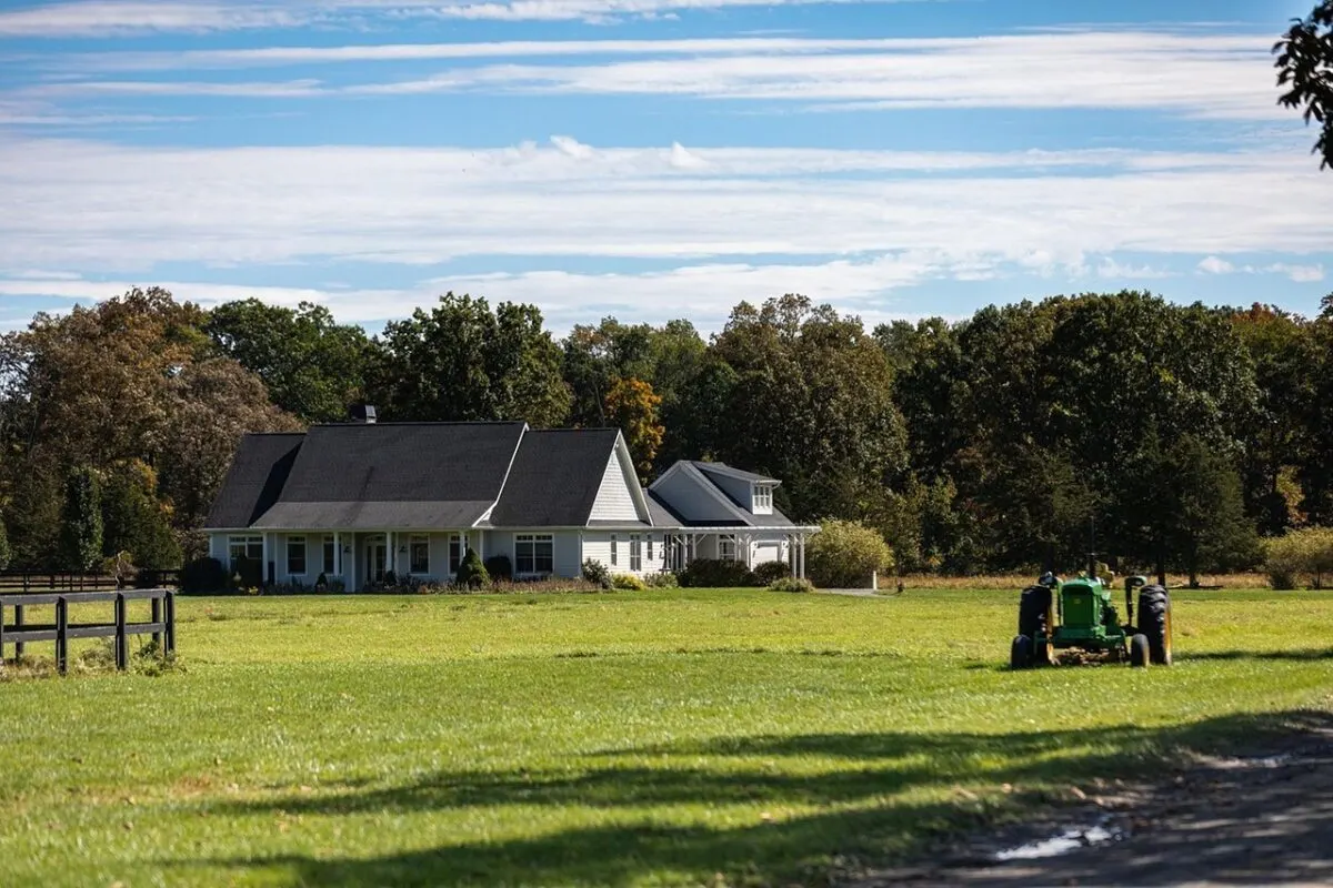 white colonial ranch home with tractor